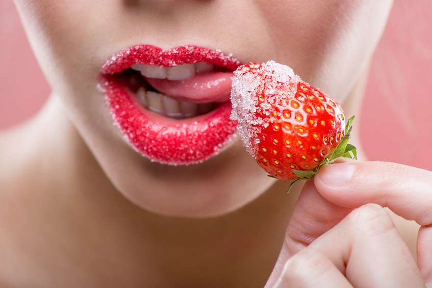 A sexy woman enjoys licking a strawberry, comparing covered oral to OWO