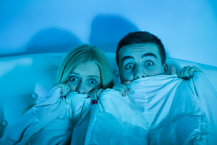 frightened couple watching a horror movie