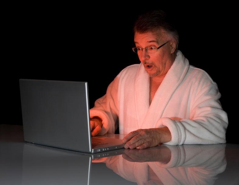 Shocked man looks at laptop