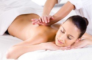 Woman leans forward being massaged