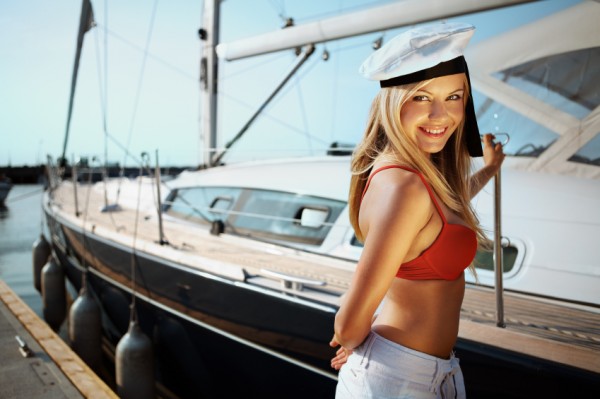 Sexy blonde woman in front of a boat