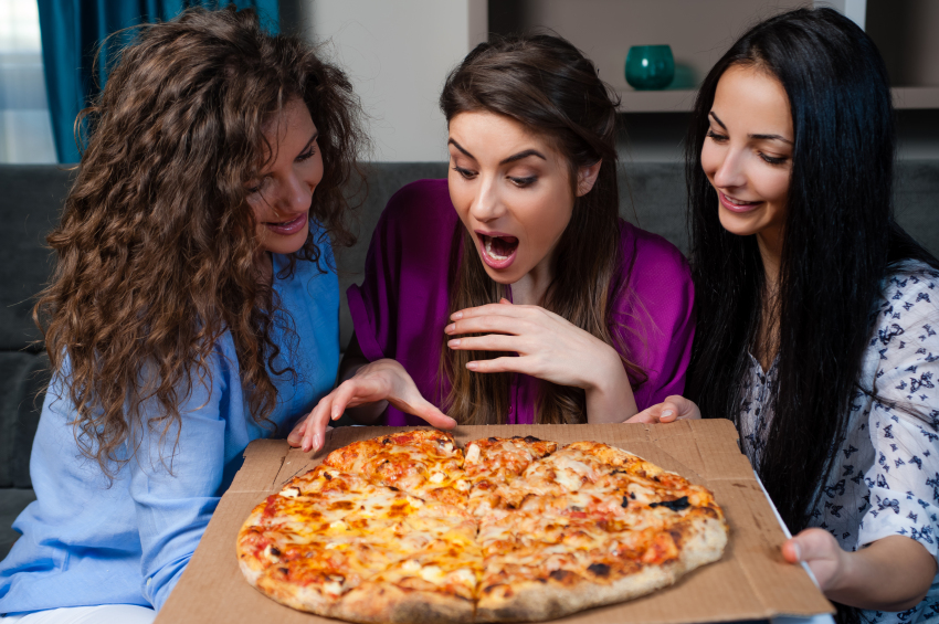 Three women with a pizza