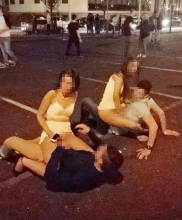 Two girls on top of two guys in car park